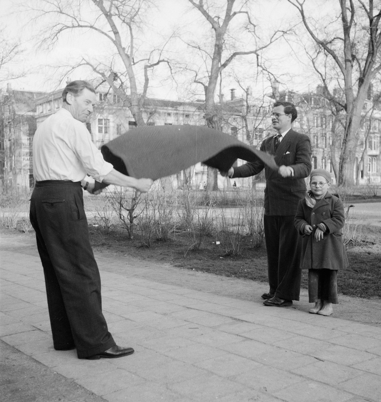 Two man and a child cleaing a carpet